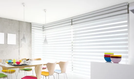 Ein Esszimmer mit buntem Geschirr und Doppelrollos.