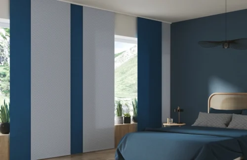 Ein minimalistisches Schlafzimmer mit Blautönen und passenden Flächenvorhängen abwechselnd in blau und grau.