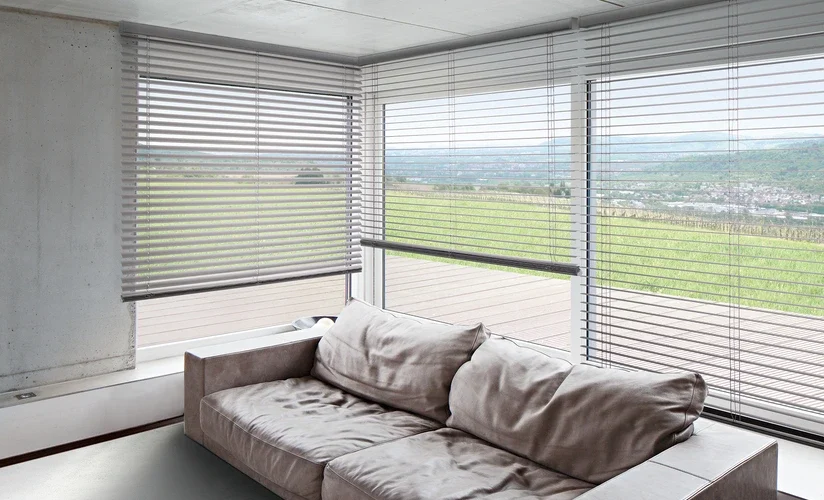 Geöffnete Jalousien komplementieren die Inneneinrichtung eines Wohnzimmers.