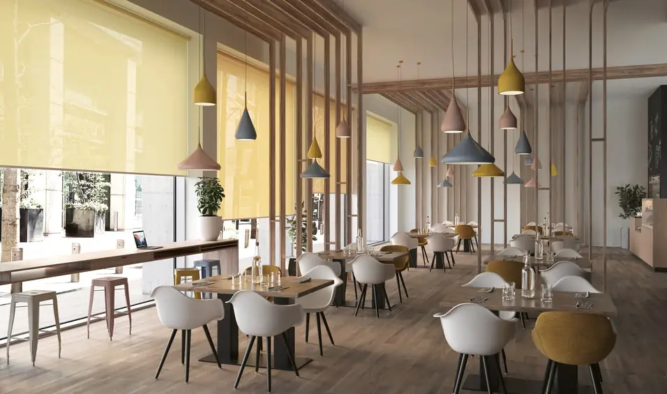 Ein helles Restaurant mit vielen hölzernen Elementen und gelben Rollos.