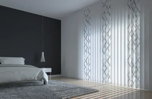 In einem schlichten modernen Schlafzimmer hängt eine weiße Vertikaljalousie mit grauen Mustern.