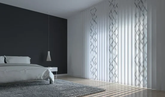 In einem schlichten modernen Schlafzimmer hängt eine weiße Vertikaljalousie mit grauen Mustern.